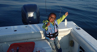 Small boy with fish on rod