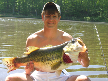 Man Holding a Largemouth Bass on Boat