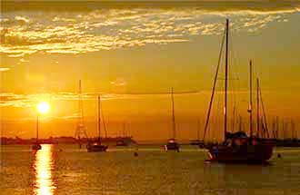 sailboats on the water at sunset