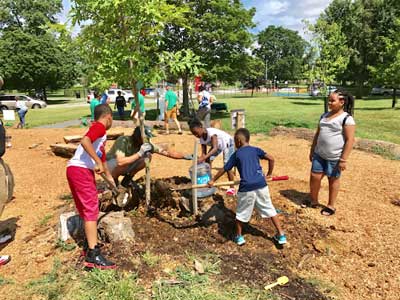 Group of kids building a planter around a tree