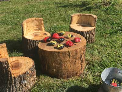 game board painted on a tree stump with rocks as playing pieces