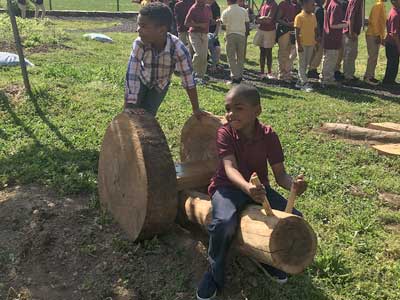 Kids sitting on a wooden caterpillar