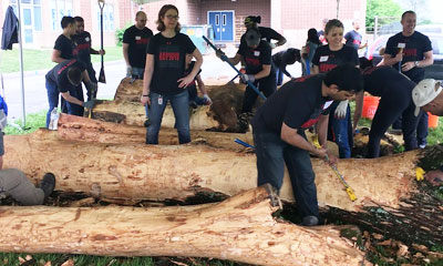 Volunteers preparing trees for a nature play space project