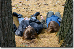 Two children lying down in the woods