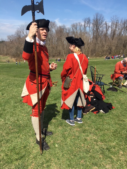 A person dressed up as a solidier holding an axe.