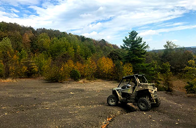 Off road vehicle with trees in the distance