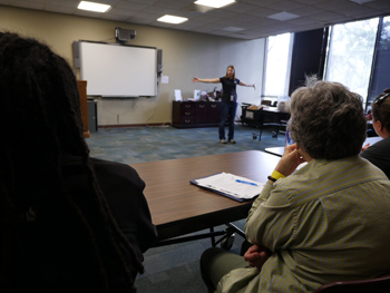 A person giving a lecture in a room of people.