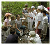 A woman talking to a group of kids.